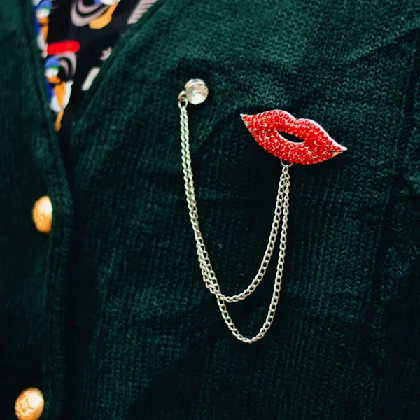 Coloured tailoring with a quirky lips brooch on the lapel