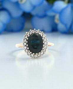 9ct Gold Sapphire and Diamond Cluster Ring with flowers in the back ground